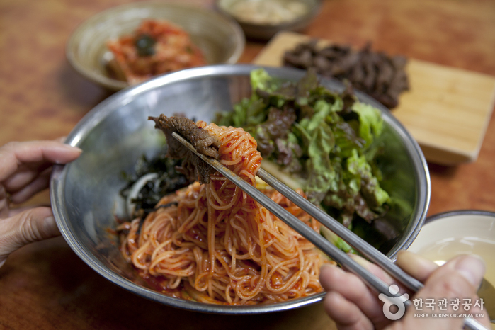 매콤한 비빔국수에 얹어 먹는 숯불고기 한 점은 매력적인 맛