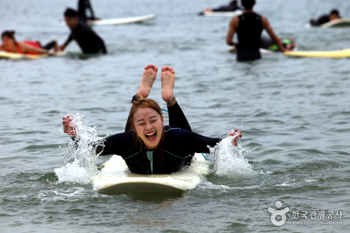 바다위에 보트를 띄워놓고 위에서 엎드려 물장구를 치고있는 모습