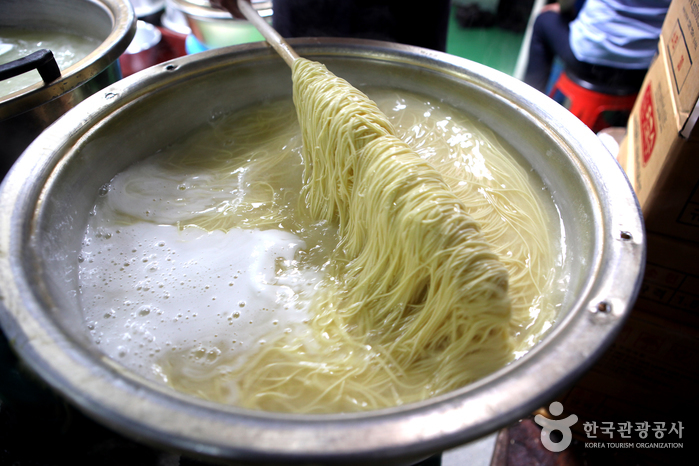 노란 치자물을 들인 면이 맛깔스럽게 끓고 있는 국수마을