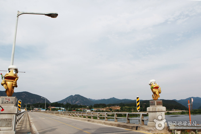 금산 인삼어죽마을에 자리한 제원대교. 인삼을 쥐고 있는 황금물고기가 반겨준다