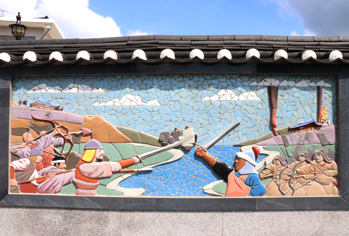 A fresco on the tiled wall depicting the construction of Goryeo Palace and fighting against the Mongol army