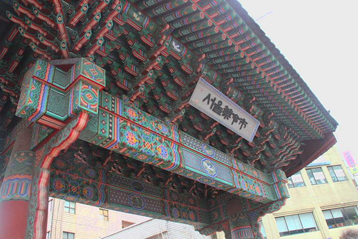 迫力ある市場のゲート（上）　/　韓方材料がずらり（左下）　/　大量の人参に圧倒される（右下）