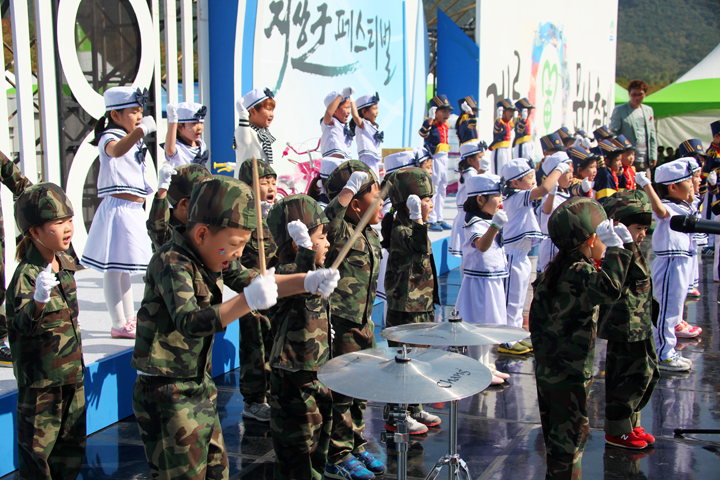 육군, 해군 복장을 한 아이들이 노래부르며 연주하는 모습