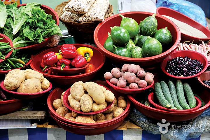 남해읍장, 빨간 바구니에 담겨있는 여러 종류의 채소들(피망, 감자, 호박, 오이, 상추, 고추 등)