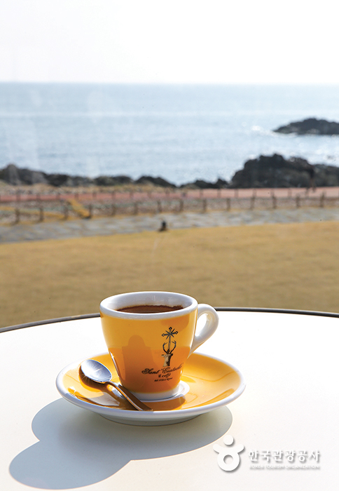 바다가 보이는 테라스, 테이블 위에 놓인 커피 한 잔