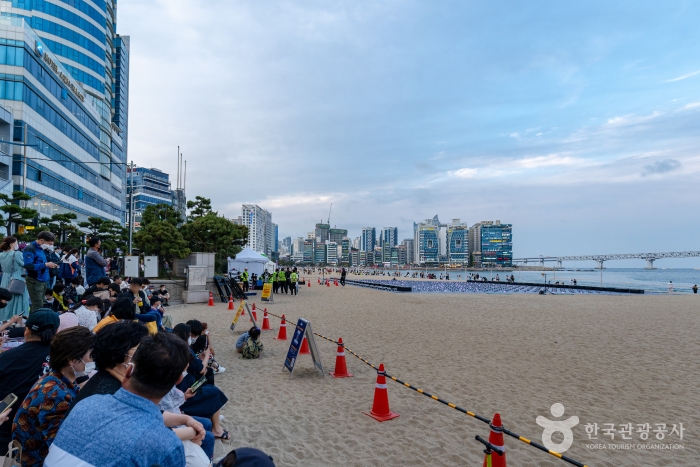 Spectators gather on the beach to watch the drone show