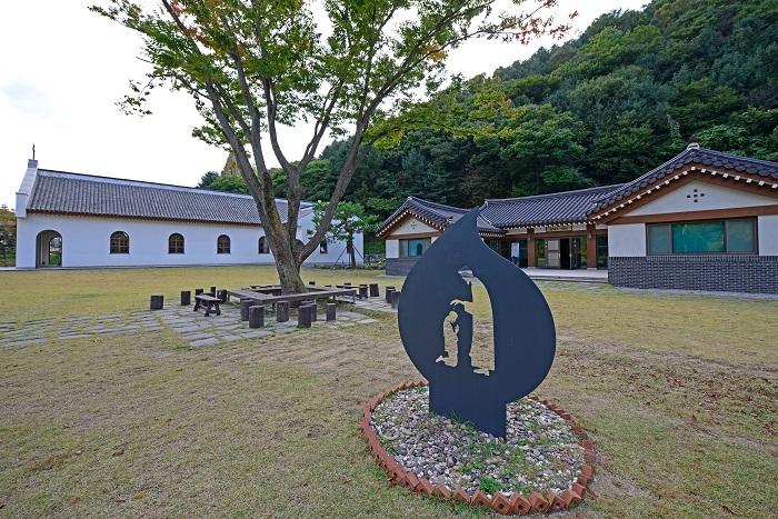 Jinjiaxiang Catholic Church and Kim Taegon Memorial Hall behind the sculpture of St. Andrew Kim Taegon