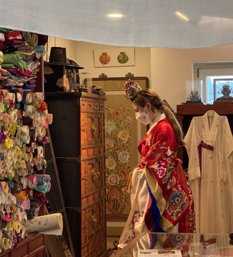 (3) Visitors trying on traditional wedding dresses