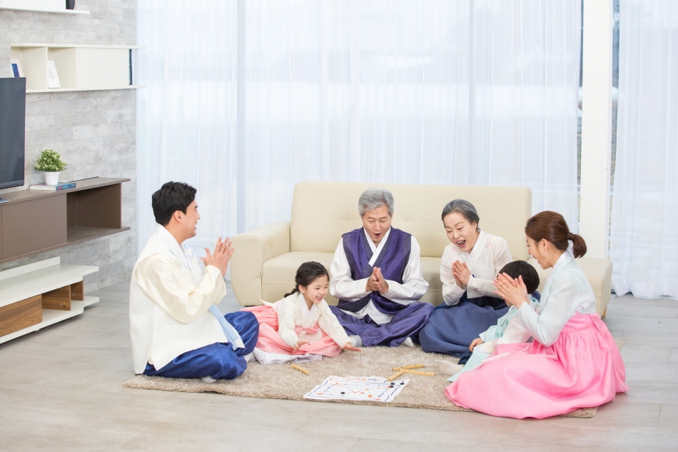 A family playing yunnori together on Seollal (Credit: Getty Images Bank)