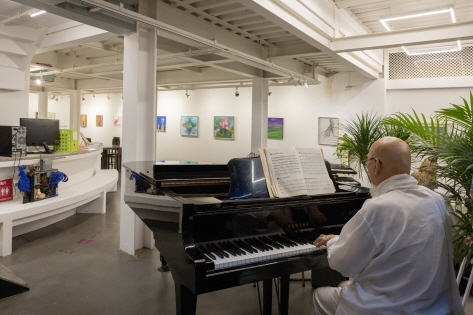 Un monje tocando el piano en la galería