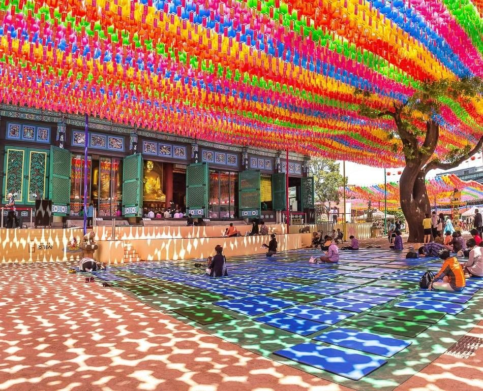 Buddhist devotees praying under lanterns
