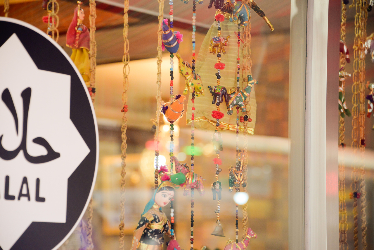 A shop window in Itaewon displaying a halal sign among colorful imported goods, Seoul